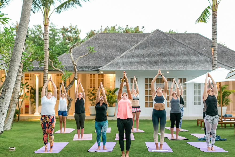 Group of women in a Yoga class stretch for the sky
